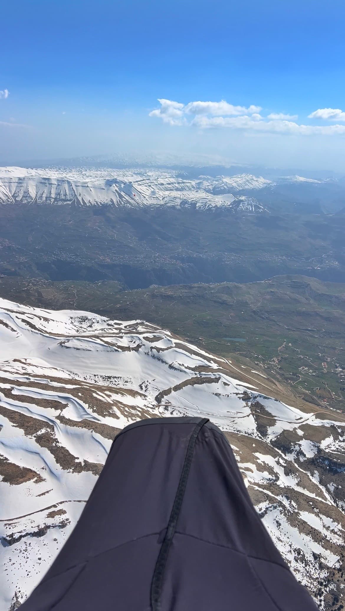 Paragliding harness view over snowy Ehden mountains and valley villages, Lebanon